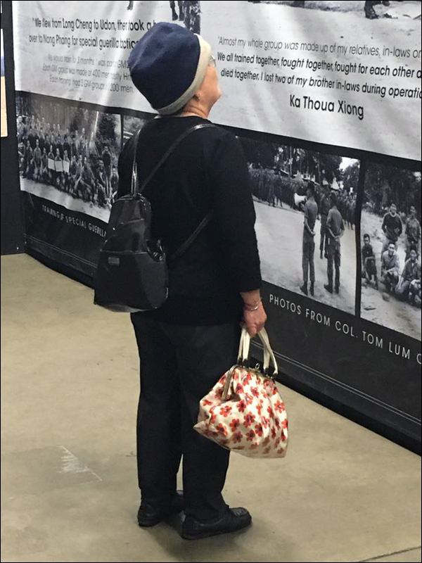 Exhibit attendee reading about the different refugee camps